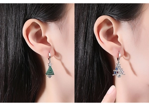 Macro view of Christmas tree earrings with colorful zircon stones on female model