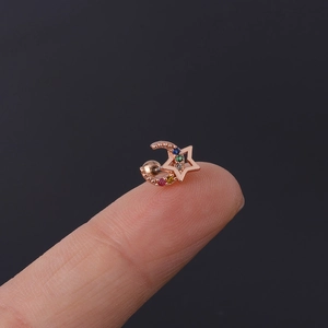 Macro view of rose gold celestial stud earring with multi-colored zircon on fingertips