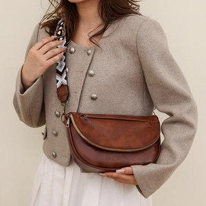 Detailed close-up of brown PU leather crossbody bag with ethnic style woven shoulder strap