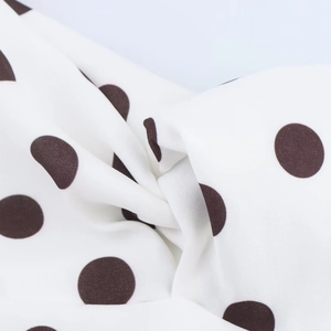 Gros plan détaillé sur un tissu blanc à pois noirs avec une texture tissée fine