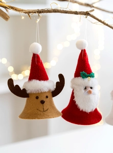 Detail of plush Santa and Reindeer ornaments with bells hanging on warm lit branches