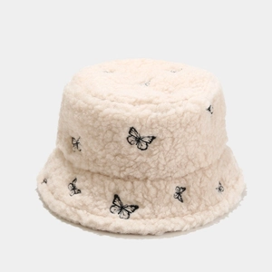 Detail of cream-colored teddy fleece bucket hat featuring delicate black butterfly embroidery