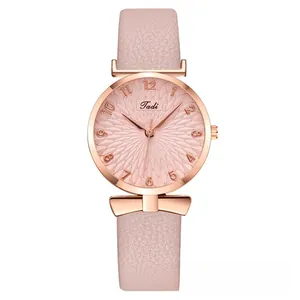 Detail of rose gold watch case with pink floral dial and elegant bow-shaped decoration