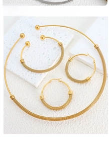 Detail showing the woven gold texture on jewelry set with collar necklace and bracelet