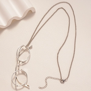 Detail of silver metallic eyeglass chain with lobster clasp on minimalist background