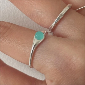 Minimalist 925 sterling silver ring with a round green crystal on a female finger