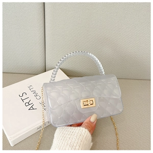 Detailed view of grey transparent jelly bag with quilted pattern and gold chain strap