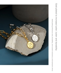 Detail of gold coin bracelets showing scratch-resistant plating and Lord's engraving