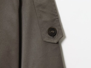 Close-up of marble texture button and premium stitching on the shoulder of a trench coat