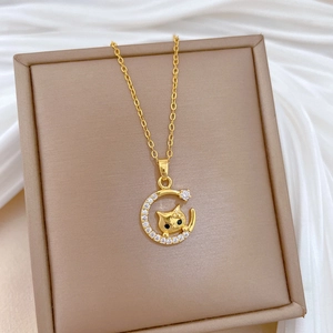Luxurious gold cat on moon pendant necklace with zircons displayed in a jewelry box