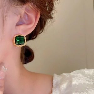 Detail view of square emerald zircon earring with gold plating on female model