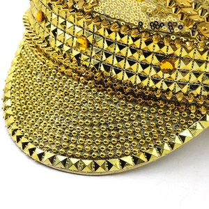 Close-up of golden bride hat with luxury sequins, rhinestones and square pyramid studs