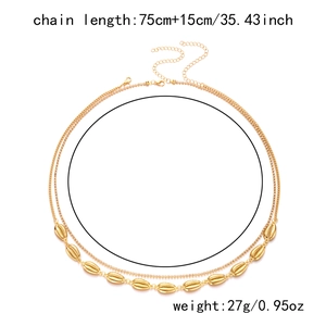 Detail of bohemian gold multi-layer waist chain with sea shell pendants and beads