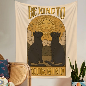 Detail of a beige wall tapestry featuring black cats and Be Kind To Your Mind text