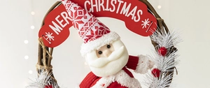 Détail d'une couronne de Noël avec un Père Noël en peluche et bannière de fête