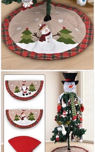 Détail du tapis de sapin de Noël avec broderies et bordure à carreaux rouge et vert