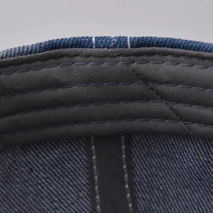Close-up of high-density stitching on the sweatband of a blue denim baseball cap