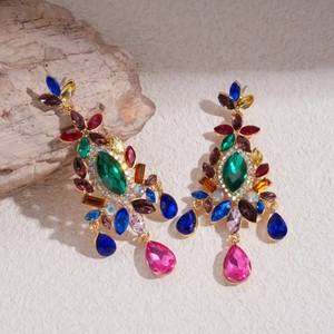 Close-up of bohemian style long crystal teardrop earrings with colorful gemstones and gold base