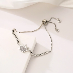 Close-up of silver crown bracelet with zircon inlay and adjustable bolo slider clasp