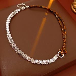 Detail of tiger eye and zircon beaded necklace with silver heart pendant on leather