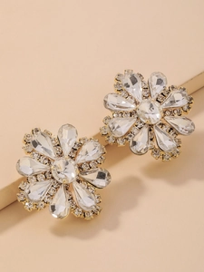 Close-up of luxury gold flower stud earrings featuring sparkling water-drop crystals