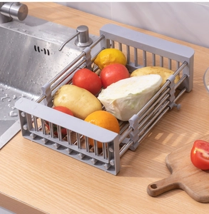 Detail of expandable stainless steel sink rack holding fresh vegetables in kitchen