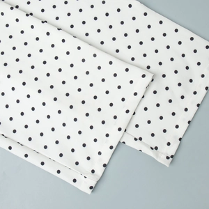 Gros plan détaillé du tissu imprimé à pois et des coutures doubles sur l'ourlet du pantalon