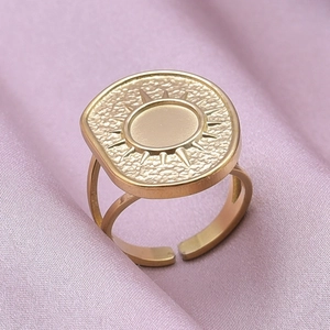 Detailed macro view of a golden sunburst engraved ring with adjustable hollow band design