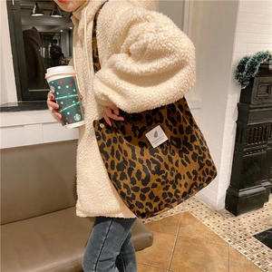 Detalle de bolso tote de pana con estampado de leopardo y etiqueta en look invernal