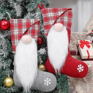 Hanging Christmas gnome stockings with white snowflakes and long beards on tree branch