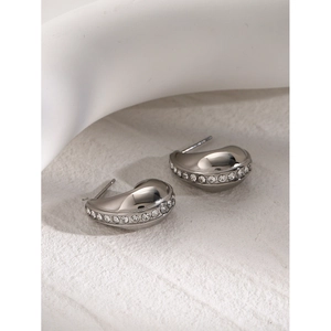 Macro shot of silver-plated C-shaped earrings with sparkling cubic zirconia inlay