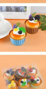 Λεπτομέρεια από έξι πολύχρωμα τεχνητά cupcakes σε διαφανές κουτί με διακοσμητικά φρούτα