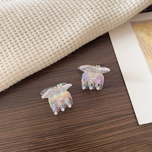 Macro detail of iridescent mini butterfly hair claws with colorful translucent finish
