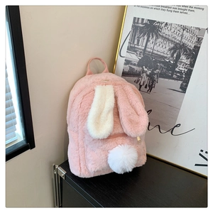 Detailed close-up of pink faux fur rabbit backpack with long ears and white pom tail