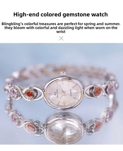 Detail of luxury women watch featuring oval colored gemstones and hollowed metal strap