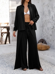 Detail of black two-piece set showing crinkled texture fabric with long sleeve shirt and pants