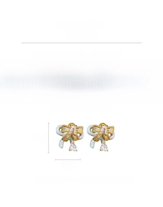 Macro detail of bow-knot earrings featuring cubic zirconia and drop pendant on white background