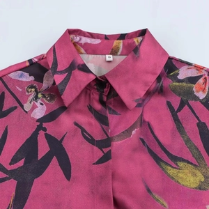 Camicia fucsia con stampa floreale artistica e bottoni neri in primo piano moda