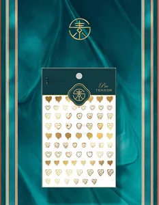 Detail of M-069 embossed gold nail stickers with artistic heart patterns on green silk