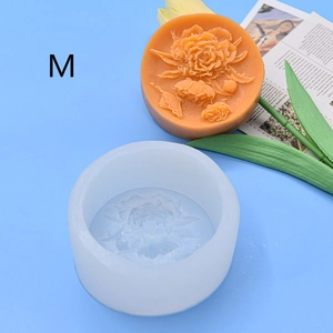 Detailed macro view of white silicone mold and orange floral soap with rose carvings