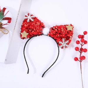 Detail of red sequined Christmas bow headband with white snowflake and gold star accents