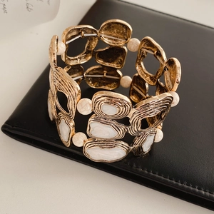 Detailed shot of vintage gold geometric bracelet with white marble stone inlays