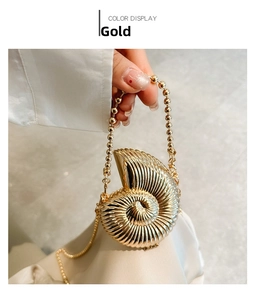 Golden nautilus shell clutch bag with beaded handle and metallic spiral texture
