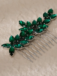 Detail showing two vintage silver hair combs with emerald green marquise rhinestones