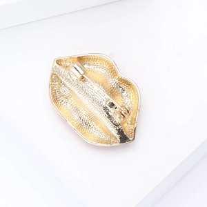 Detailed back view of gold-tone lip-shaped brooch showing sturdy pin mechanism