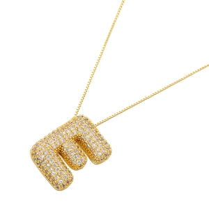 Detailed macro of 18K gold plated bubble letter E pendant with zircon pave setting