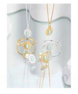 Macro shot of elegant S925 sterling silver opal necklace and ring set in gold finish.