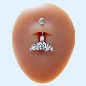 Macro detail of silver whale tail belly ring with sparkling crystals on silicone model
