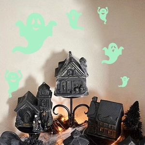 Luminous green ghost stickers glowing in a dark Halloween themed festive scene setup