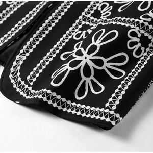 Close-up of the black fabric featuring detailed white geometric and floral prints